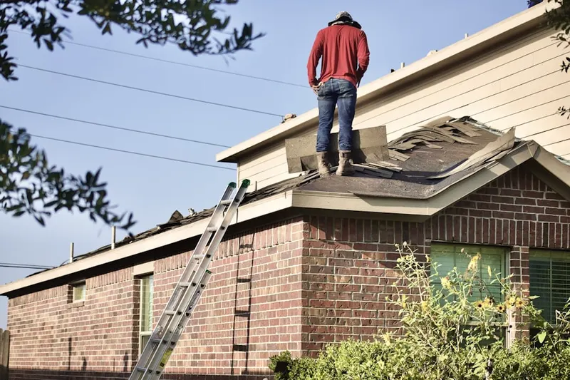 Professional roofer working on a residential roof in Irondequoit